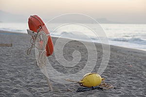 lifebuoy hanging on a wooden pole on the beach and the backdrop of sea at sunset. Saving life concept.