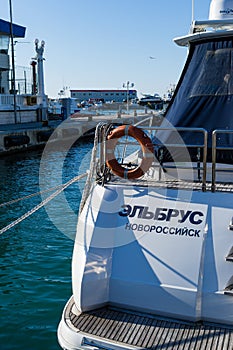 Lifebuoy or orange life ring on white ship Elbrus from Novorossiysk with Black sea backdrop. Safety equipment,