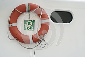 A lifebuoy, ring buoy, lifering, life donut, life preserver on the white wall of boat or yacht