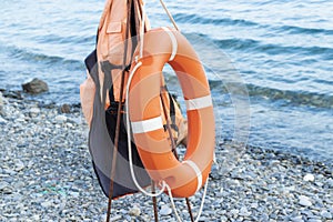 Lifebuoy ring and a life jacket near on a seaside in summer, lifeguard rescue equipment