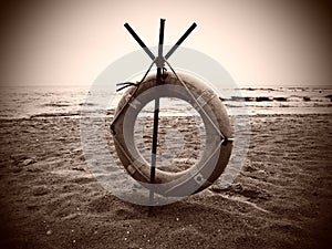 Lifebuoy on a sandy beach. Orange circle on a pole to rescue people drowning in the sea. Rescue point on the shore. Sky