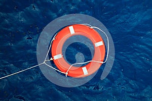 Lifebuoy in a stormy blue sea, safety equipment in boat.
