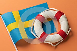 Lifebuoy and Sweden flag on a colored background, concept on the theme of help