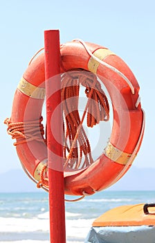Lifebuoy to save peopleon beach on blue sea background