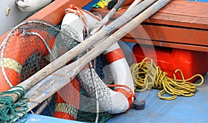 Lifebuoys fishing nets and oars in a boat moored