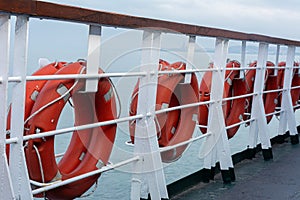 Lifebuoys hang on board a sea ferry floating on the waves