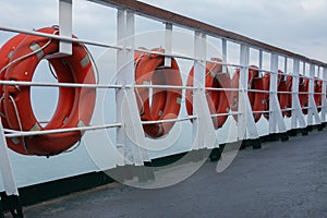Lifebuoys hang on board a sea ferry floating on the waves