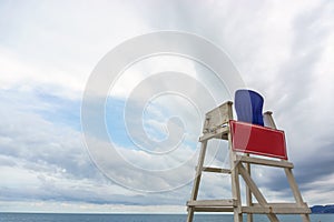 Lifeguard chair on the beach against a cloudy sky