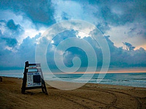 Lifeguard chair on beach with storm clouds