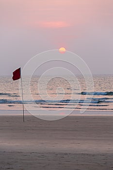 Lifeguard flag in sunset at Agonda Beach, Goa, India