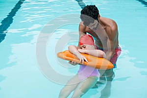 Lifeguard rescuing girl from swimming pool