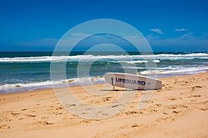 Lifeguard surfboard on ocean beach on sunny day