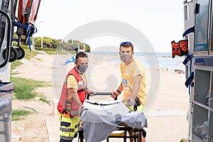 Lifeguard team working on the beach using a stretcher