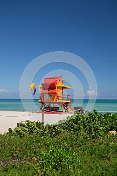 Lifeguard tower in a colorful Art Deco style, with blue sky and Atlantic Ocean in the background. World famous travel location. So