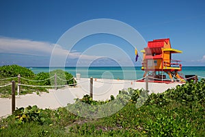 Lifeguard tower in a colorful Art Deco style, with blue sky and Atlantic Ocean in the background. World famous travel location. So