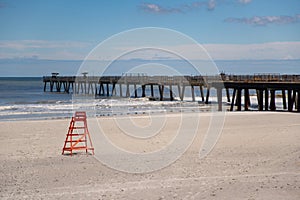 Lifeguard tower at empty Jacksonville Beach FL closed Coronavirus Covid 19 pandemic focus on chair