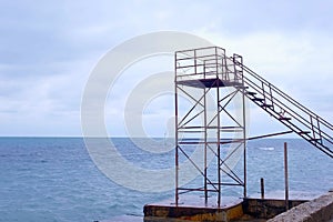 Lifeguard tower at empty waterfront beach in the off-season. Windy day and stormy sea.