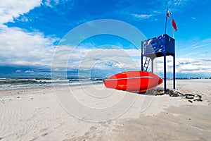 Lifeguard tower and lifeboat on the beach - with blue cloudy sky