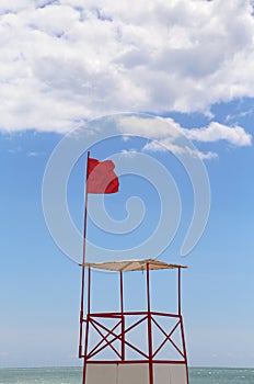 Lifeguard tower with red flag in resort beach