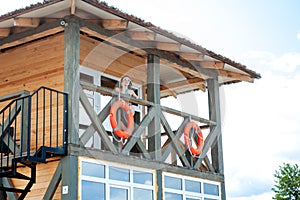 Lifeguard tower for rescue baywatch on beach. Wooden house on sea shore on cloudy sky background. Summer vacation and resort.