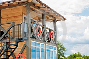 Lifeguard tower for rescue baywatch on beach. Wooden house on sea shore on cloudy sky background. Summer vacation and resort.