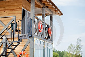 Lifeguard tower for rescue baywatch on beach. Wooden house on sea shore on cloudy sky background. Summer vacation and resort.