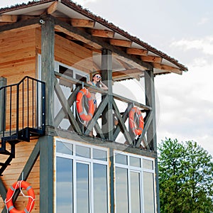 Lifeguard tower for rescue baywatch on beach. Wooden house on sea shore on cloudy sky background. Summer vacation and resort.