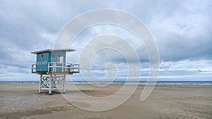 Lifeguard tower on the sand of Deauville beach in panorama with cloud sky