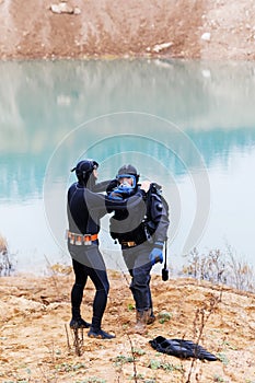 Lifeguard in a wetsuit to work underwater. Search at the bottom of the pond.