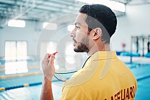 Lifeguard, whistle and swimming pool safety by man watching at indoor facility for training, swim and practice. Pool