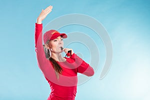 Lifeguard woman in cap on duty blowing whistle.