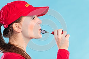 Lifeguard woman in cap on duty whistling.