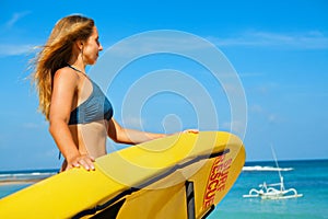 Lifeguard woman stand with surf rescue board on beach