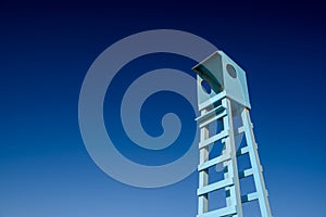 Lifeguard wooden rescue tower at the sea beach on blue sky