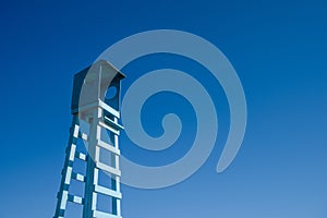 Lifeguard wooden rescue tower at the sea beach on blue sky