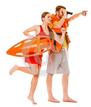 Lifeguards in life vest with rescue buoy running