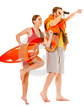 Lifeguards in life vest with rescue buoy running