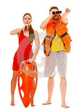 Lifeguards in life vest with rescue buoy whistling