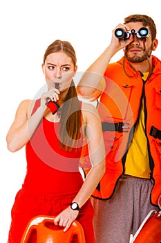 Lifeguards in life vest with ring buoy whistling.