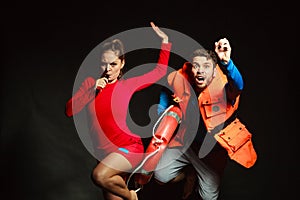 Lifeguards in life vest with ring buoy whistling.