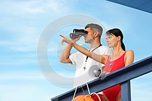 Lifeguards with megaphone and binocular on watch tower against blue sky