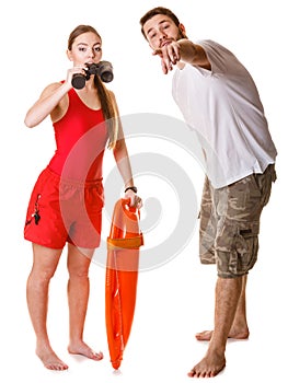Lifeguards with rescue buoy and binoculars.