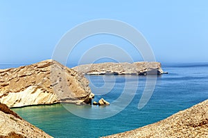Lifeless rocky islands under the scorching sun off coast of Oman in the Gulf of Oman