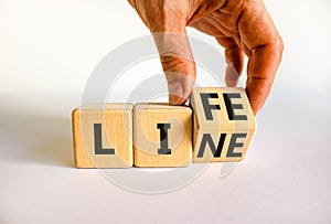 Lifeline, line of life symbol. Businessman turns the wooden cube and changes the word Life to Line. Beautiful white table white