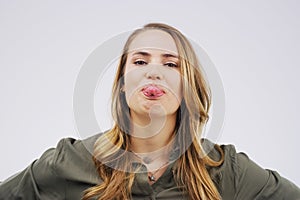 Lifes too short not to have a sense of humour. Studio shot of a young woman making a funny face against a gray