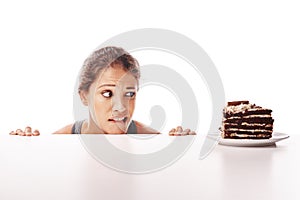 Lifes too short to say no to cake. Studio shot of an attractive young woman being tempted by something sweet.