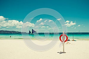 Lifesaver equipment on tropical white sand paradise beach. Red lifebuoy. Life insurance helping concept. Travel to Philippines.