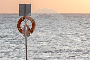 Lifesaver flotation ring. Beach lifebuoy ring on stand in front photo