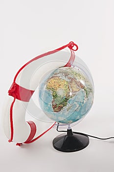 Lifesaver and globe against white background