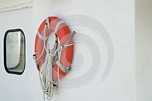 Lifesaver, Orange Life Ring mounted on boat near porthole